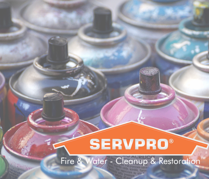 SERVPRO logo with cans of spray paint in background