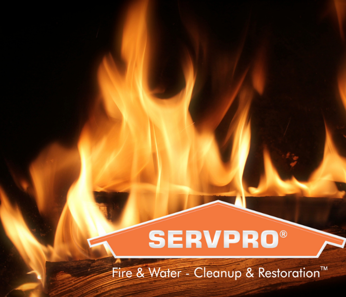 SERVPRO logo with logs on fire behind it