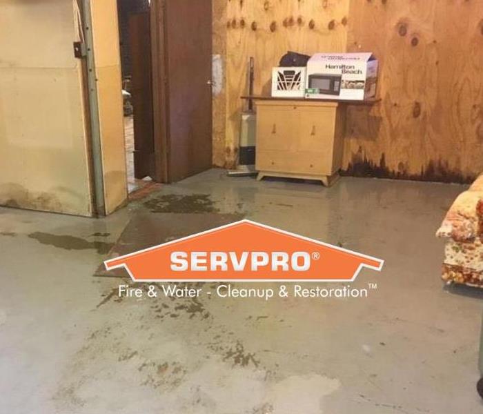 SERVPRO logo with water damaged room with Hamilton Beach microwave box in background