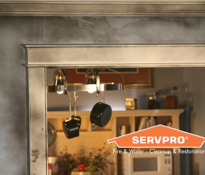 SERVPRO logo with soot on doorway above and around the logo