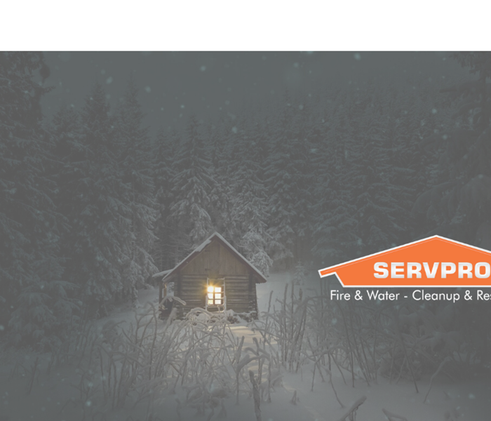 SERVPRO logo with snow and lit up house in background