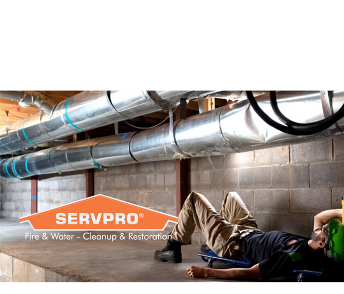 SERVPRO logo with man shining flashlight on ductwork