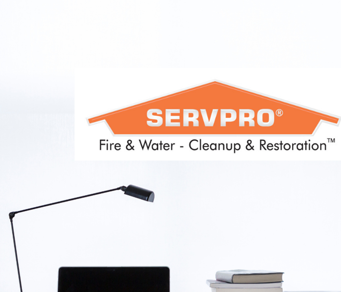 SERVPRO logo with lamp, computer and books on a desk