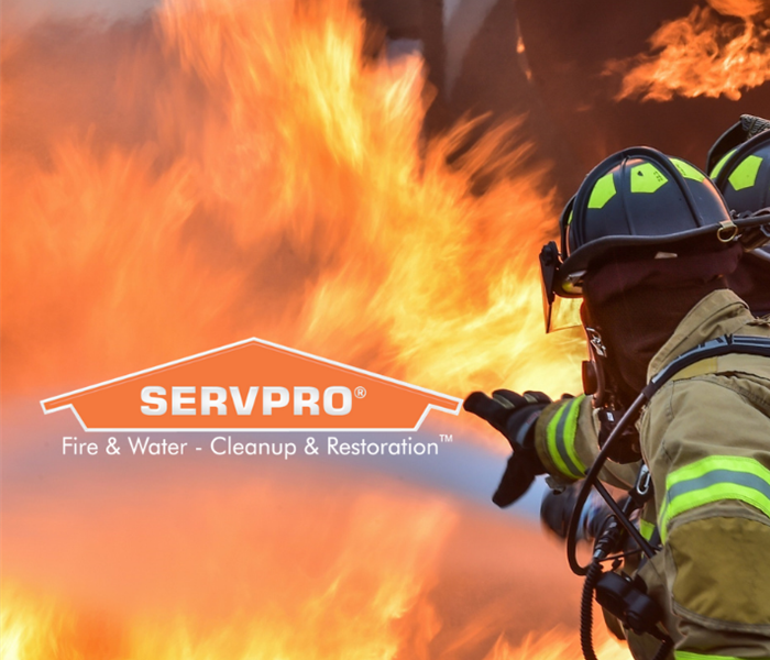 SERVPRO logo with firemen spraying water on flames