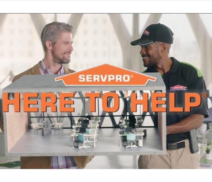 SERVPRO employee and customer holding model of an office.