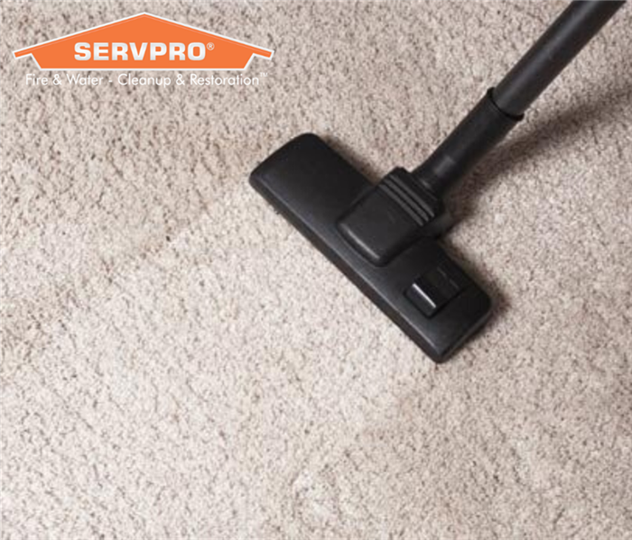 Carpet with SERVPRO logo and cleaning equipment.