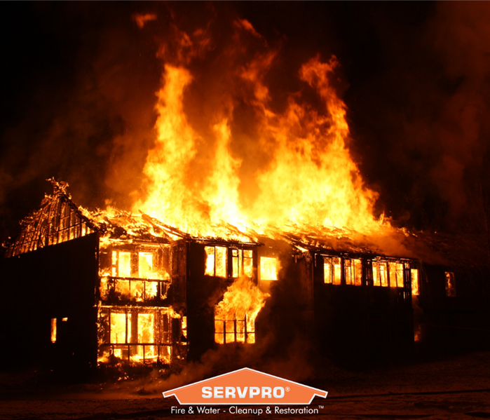 SERVPRO logo in front of a house on fire